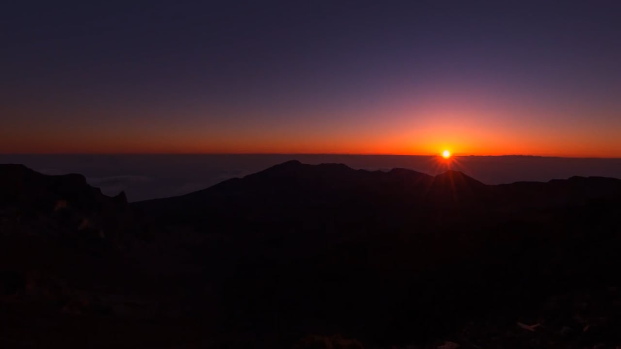 Sunrise above mountain peaks in the Kinetic Productions intro reel